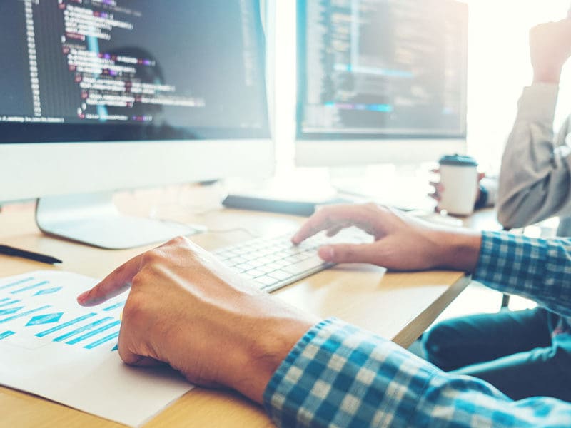 A man is busy coding a website and developing it.