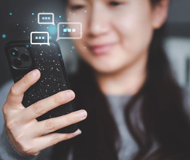 A lady texting on her phone with text symbols behind it