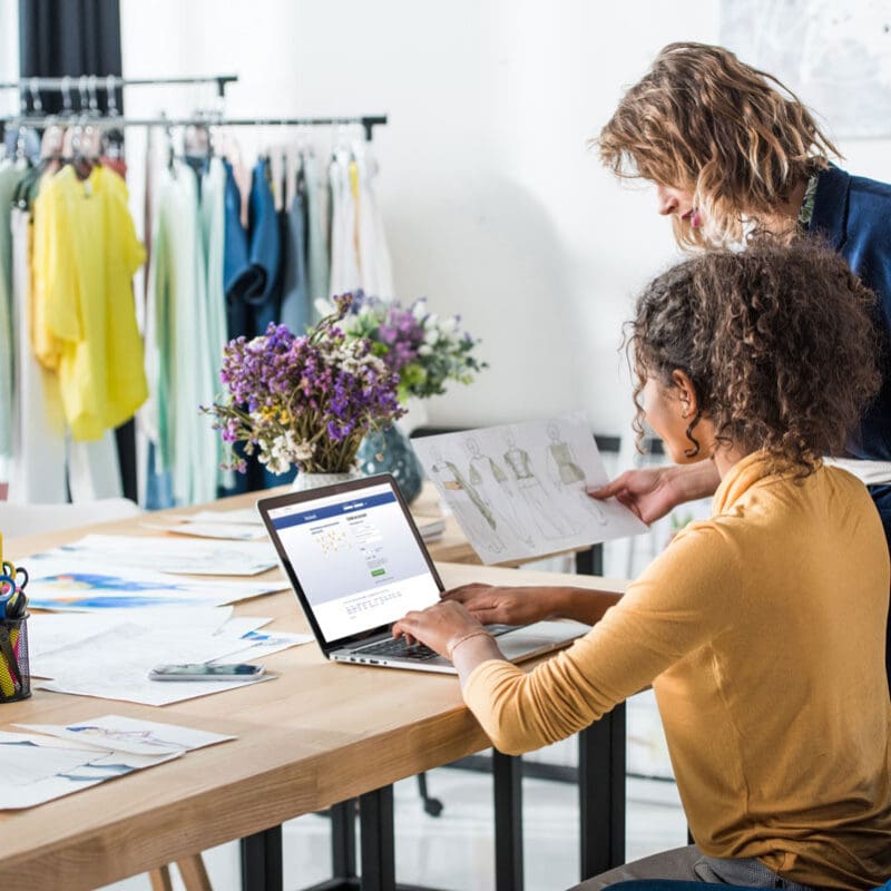 Two creative professionals reviewing design sketches and working on brand development at a collaborative workspace