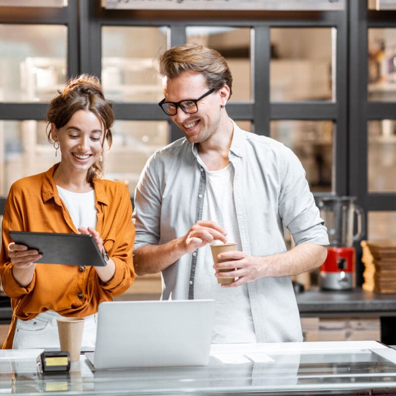 Small business owners reviewing digital tools together, representing logistics website development and SEO for logistics companies