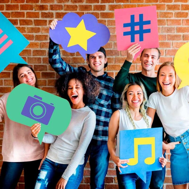 Group of young professionals holding social media icons representing likes hashtags comments and content sharing