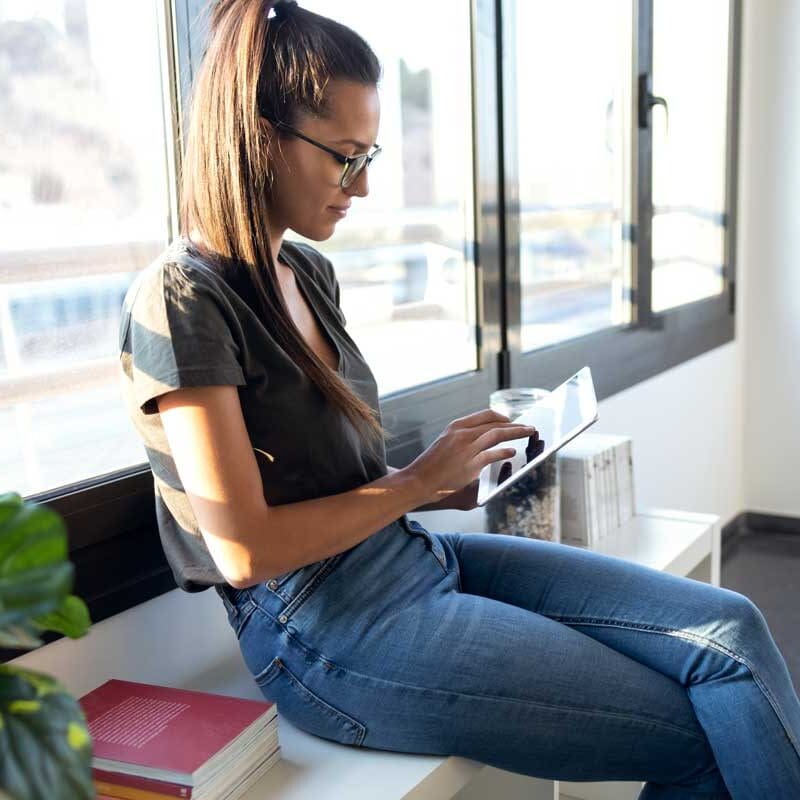 Woman using a tablet while working on digital marketing tasks in a bright modern office space