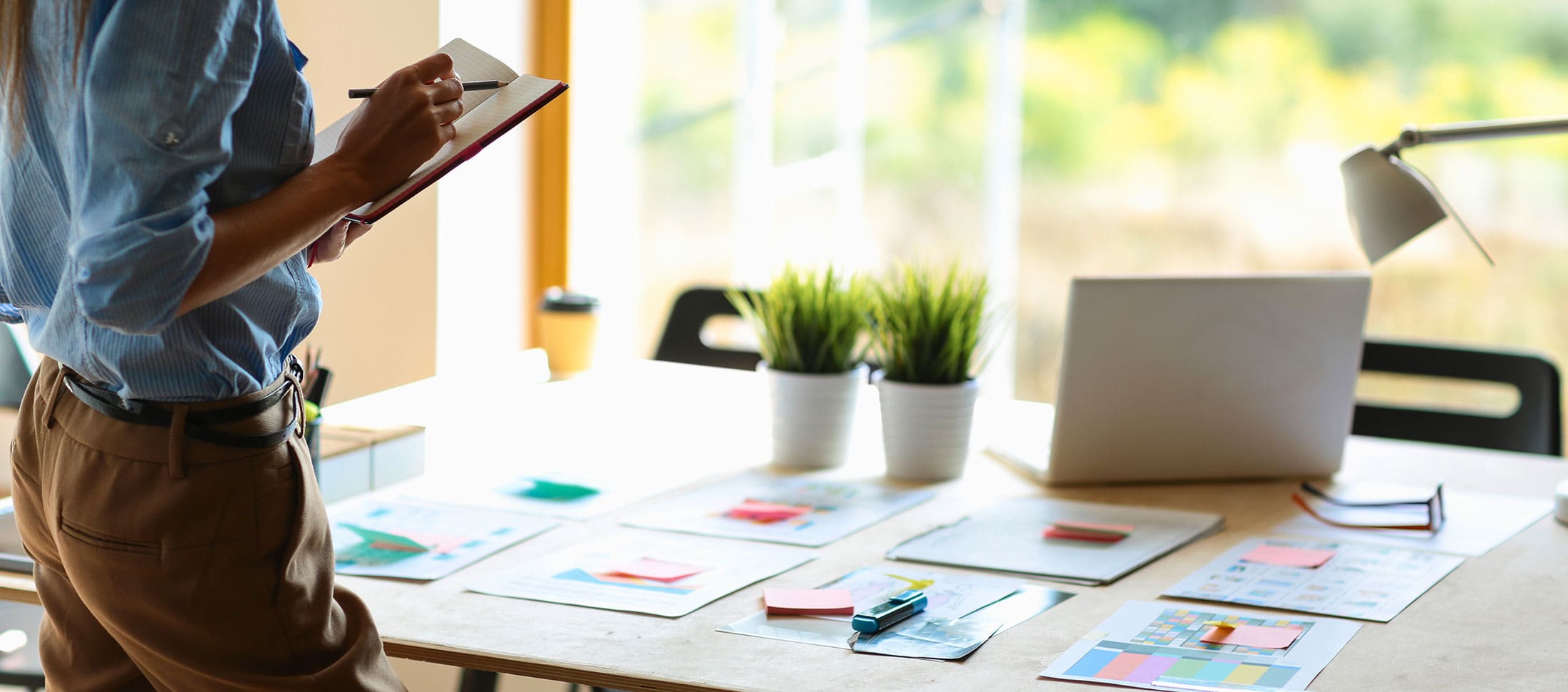Marketing strategist reviewing branding materials and campaign plans at a desk