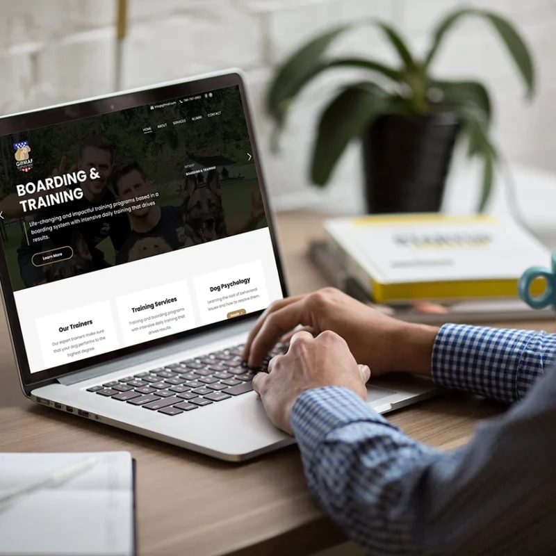 Person working on a laptop displaying a professional business website design in a modern workspace