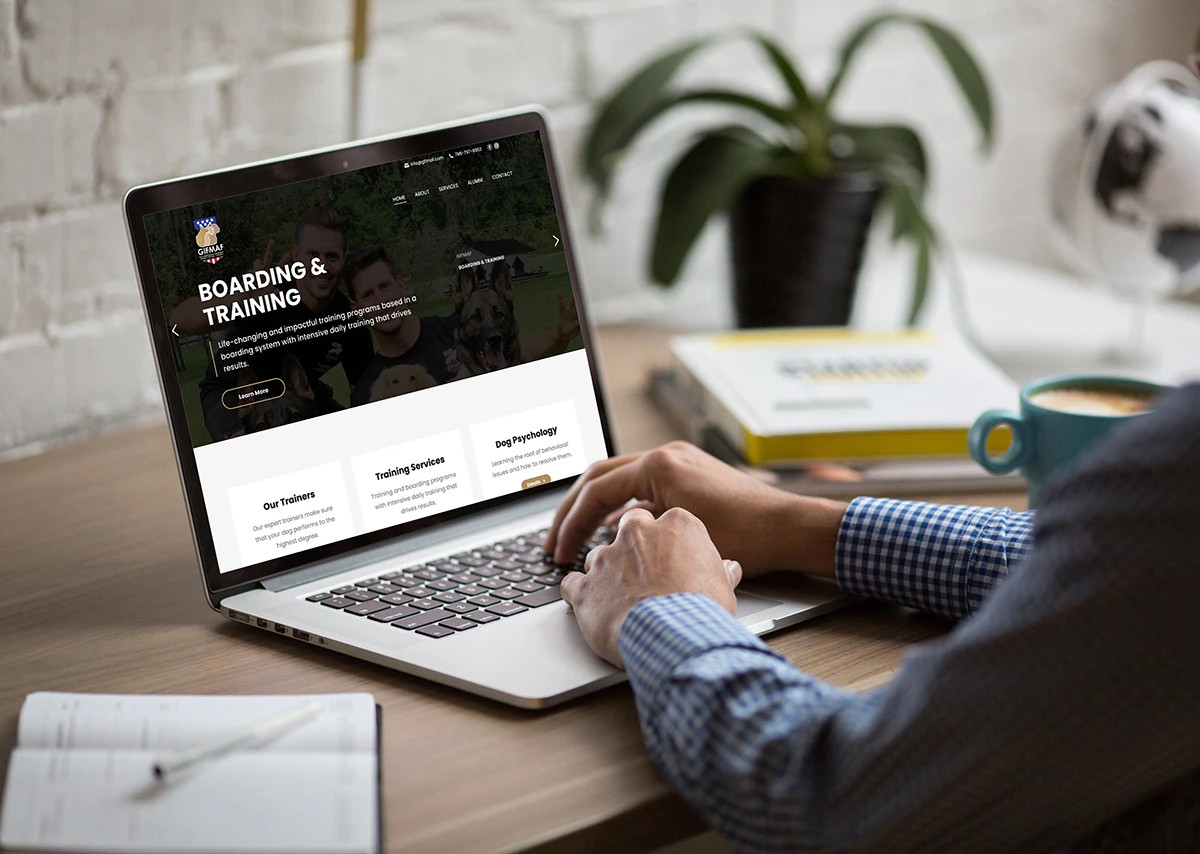 Person working on a laptop displaying a professional business website design in a modern workspace