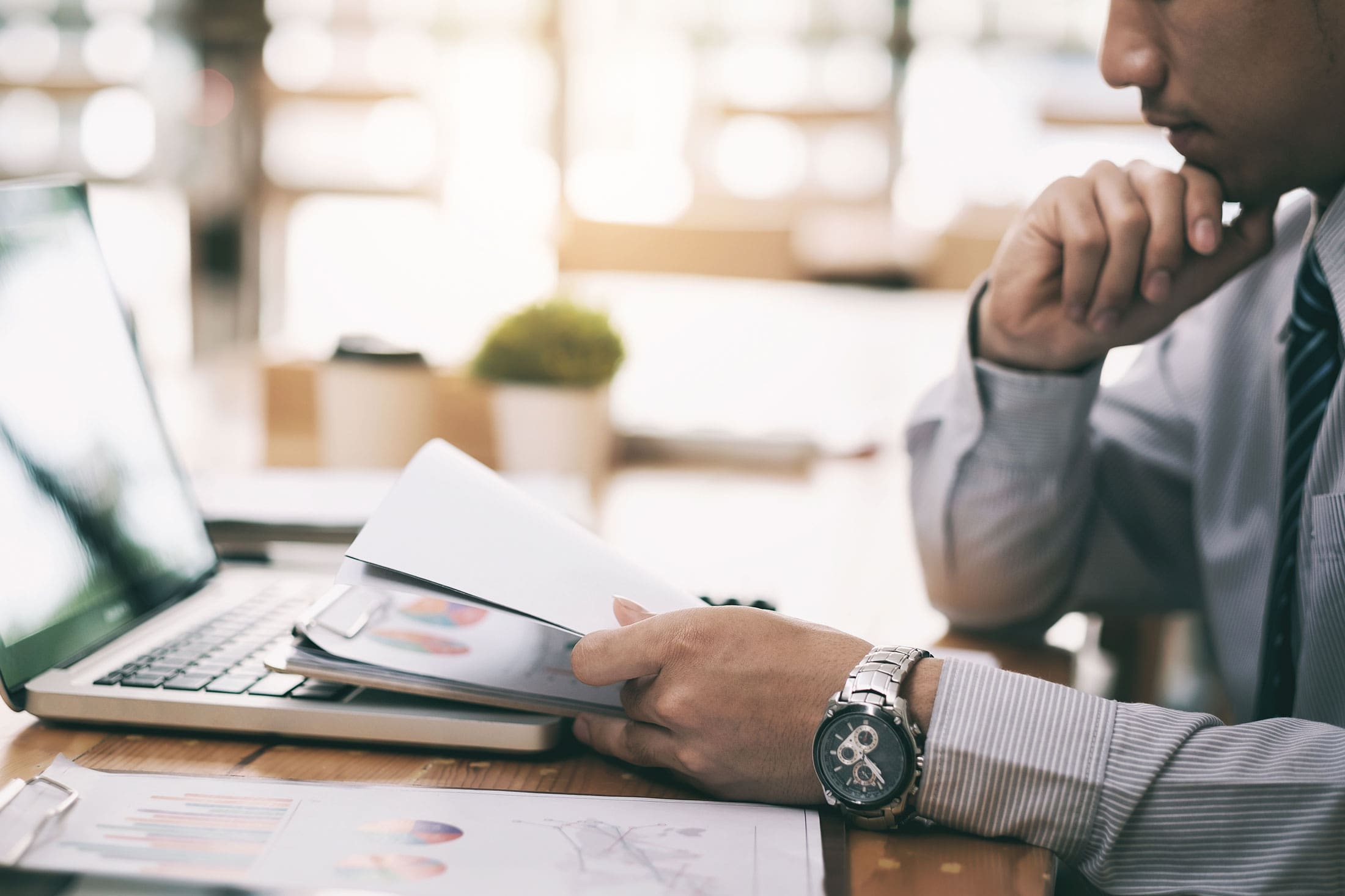 Business man reading notes in front of his laptop
