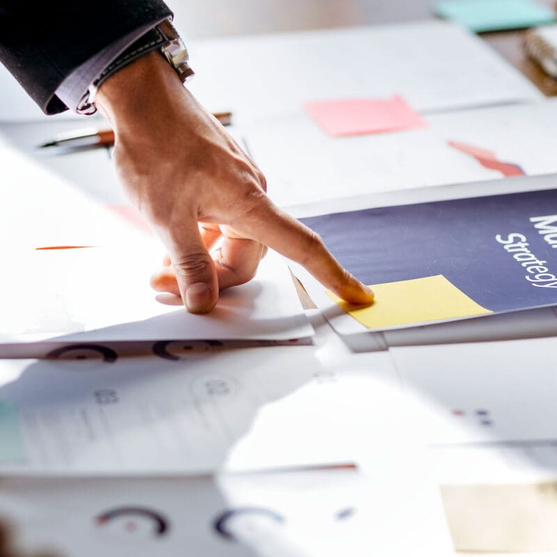 Hand reviewing logistics website development strategy and SEO planning documents