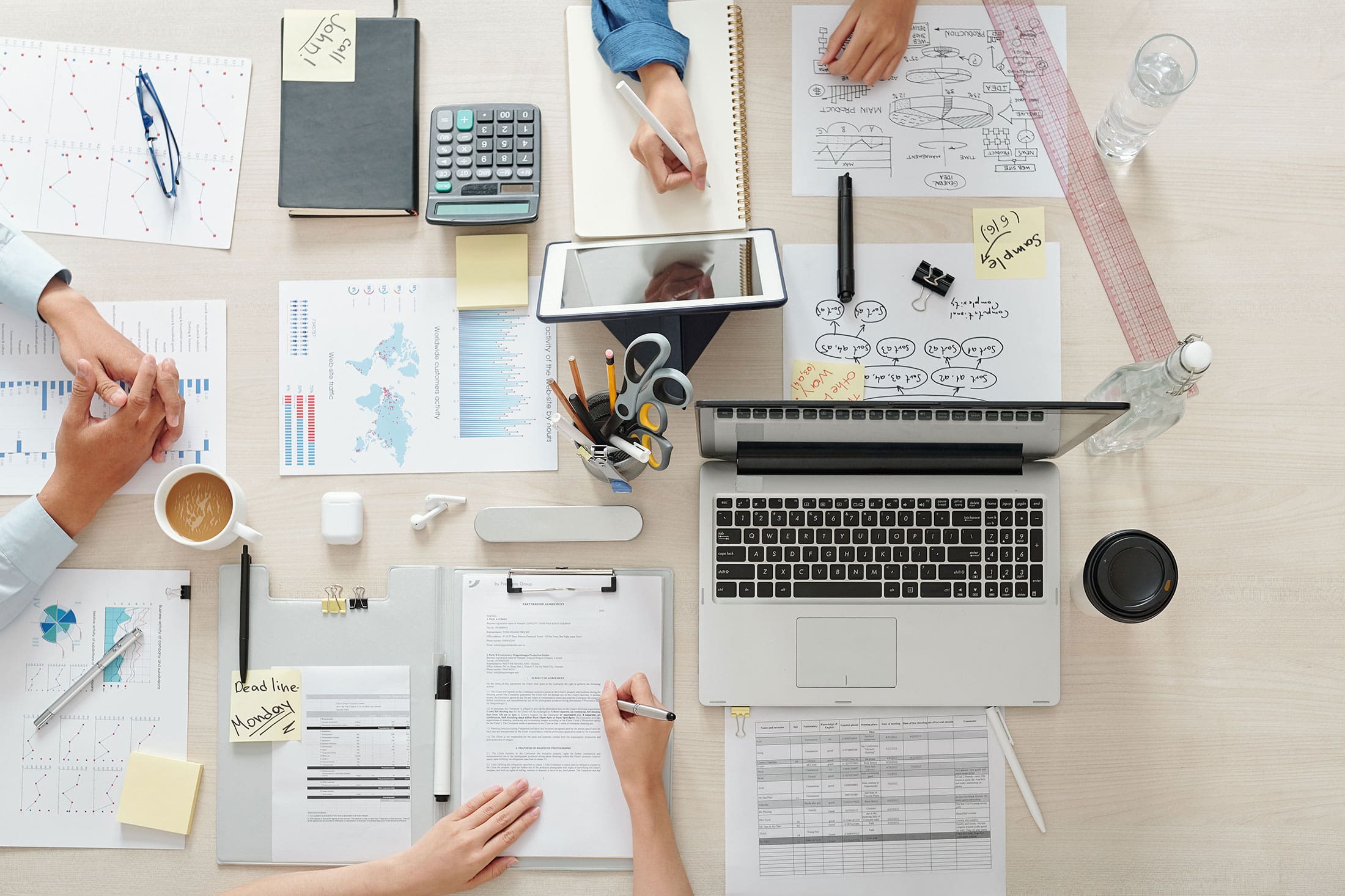 Overhead view of a marketing team working on data analysis, planning, and strategy at a shared workspace