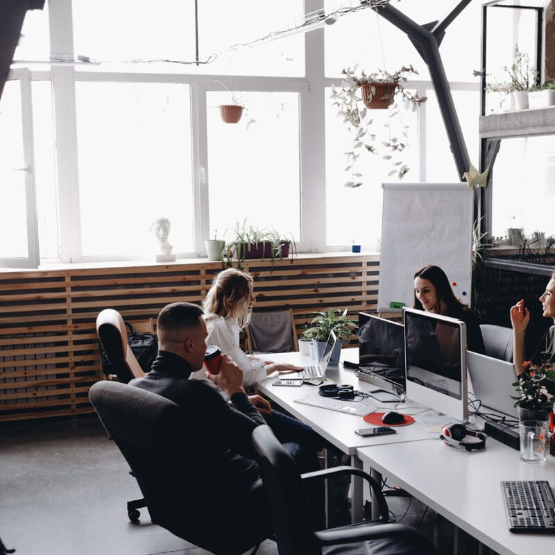 Marketing team collaborating in a modern office workspace while reviewing digital advertising strategies