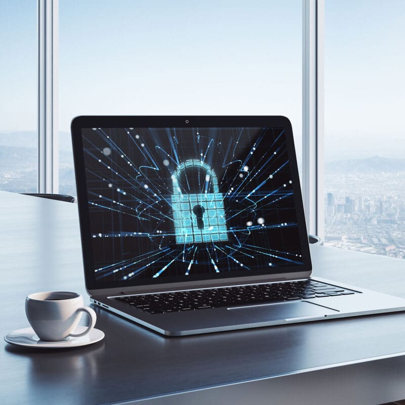 Laptop on a conference table displaying a glowing digital padlock graphic, symbolizing cybersecurity and website protection in a modern office setting.