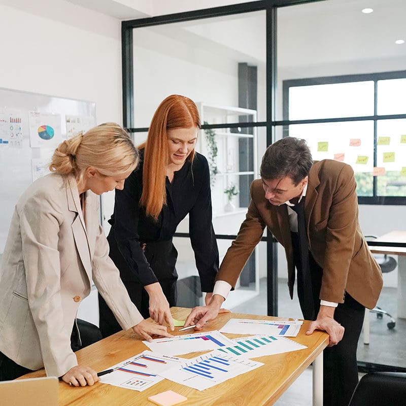 A team of three marketing creatives analysing statistics with the team in an office