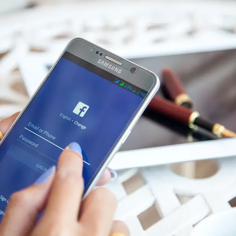 A lady is logging in to her Facebook account on her phone