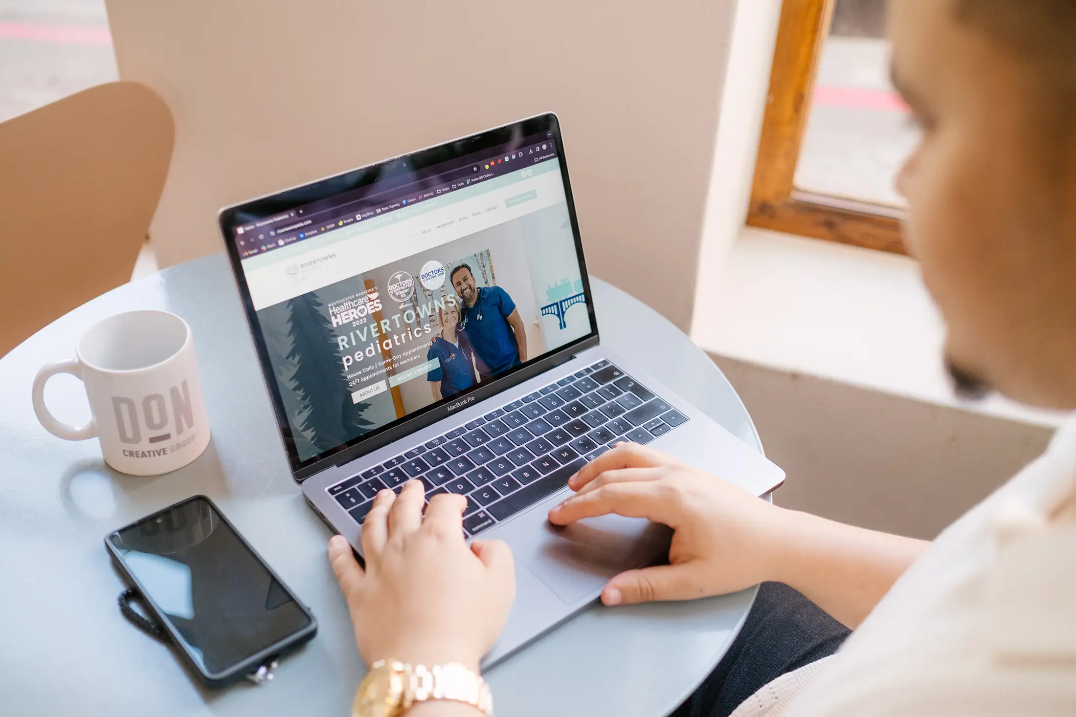 Designer reviewing pediatric healthcare website on laptop during professional web design workflow