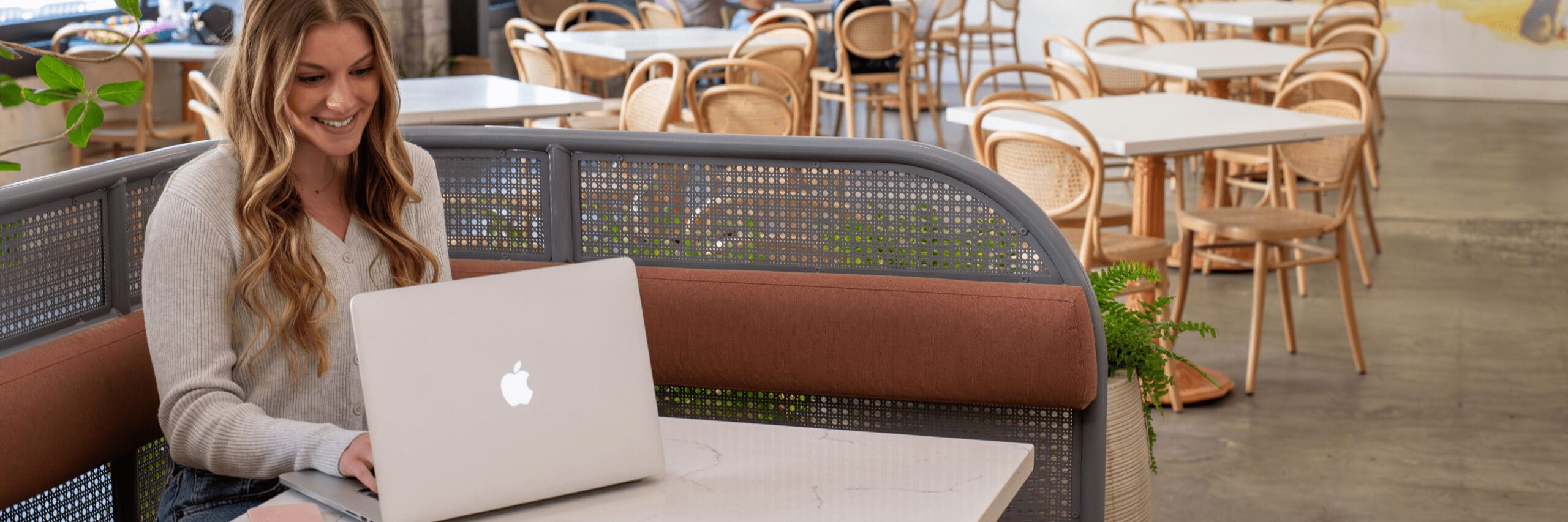 Social Media Manager of Don Creative Group working on her laptop looking at Social Media Analytics in a cafe