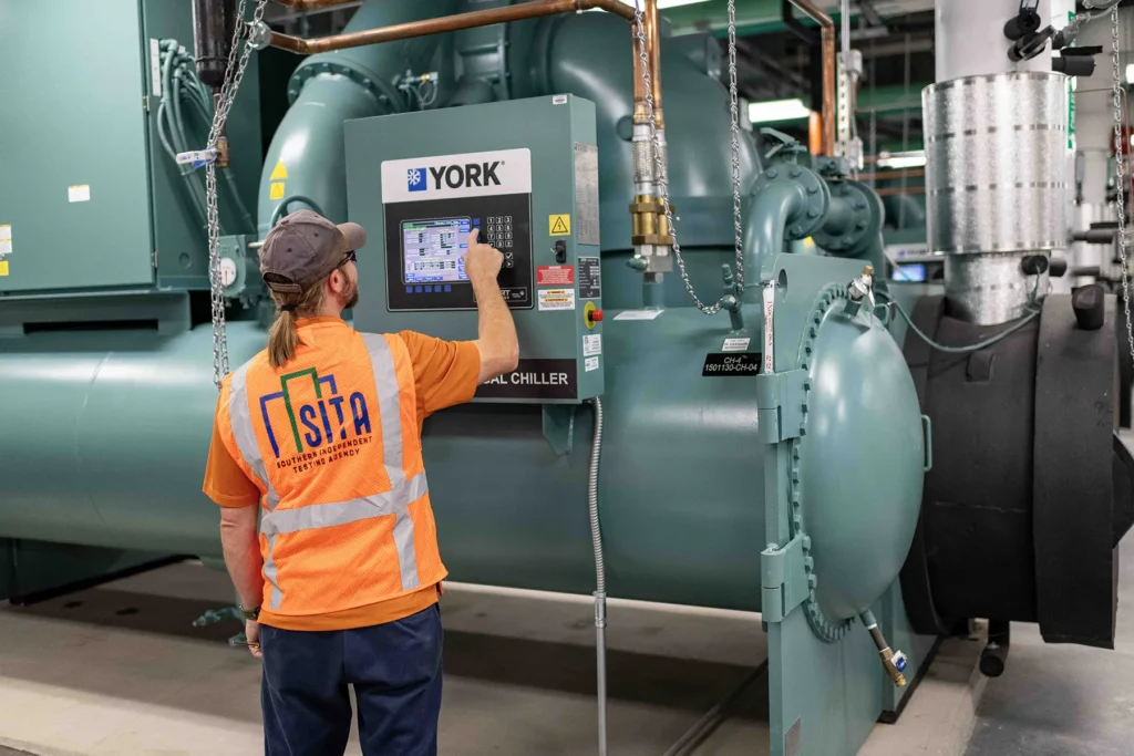 Commercial Chiller Testing by Southern Independent Testing Agency SITA technician operating a YORK commercial chiller control panel during HVAC system testing