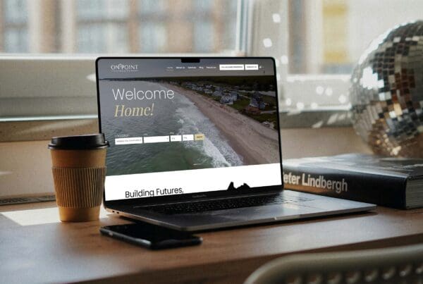 OnPoint Realty website displayed on a laptop showcasing a coastal real estate homepage