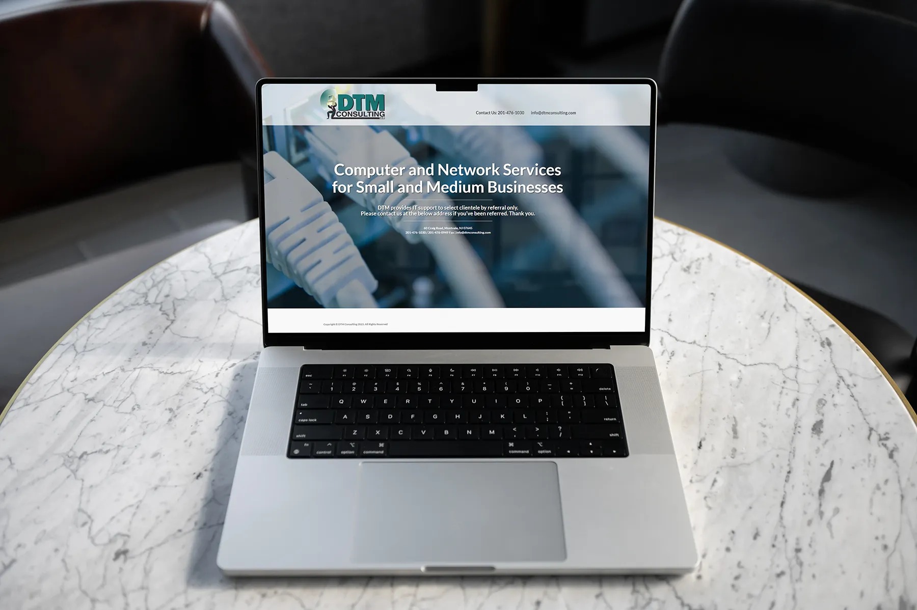 DTM Consulting website displayed on laptop showcasing computer and network services