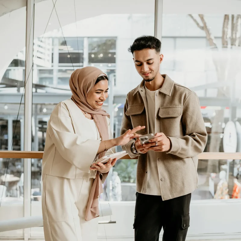 Two professionals reviewing mobile content together as part of logistics website development planning