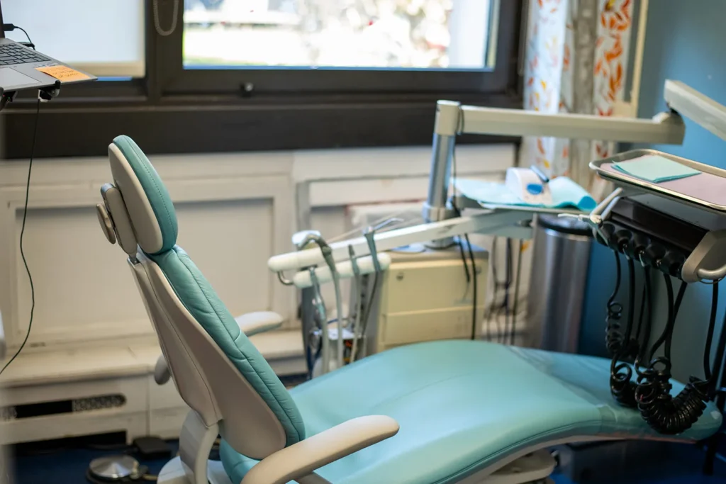 Pediatric dental exam room with modern chair and equipment Empty pediatric dental chair and treatment equipment in a clean, welcoming exam room