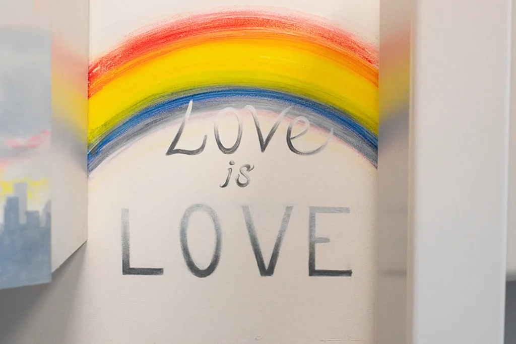 Love is Love rainbow artwork in inclusive pediatric office Rainbow wall art with the words Love is Love displayed in a pediatric healthcare setting
