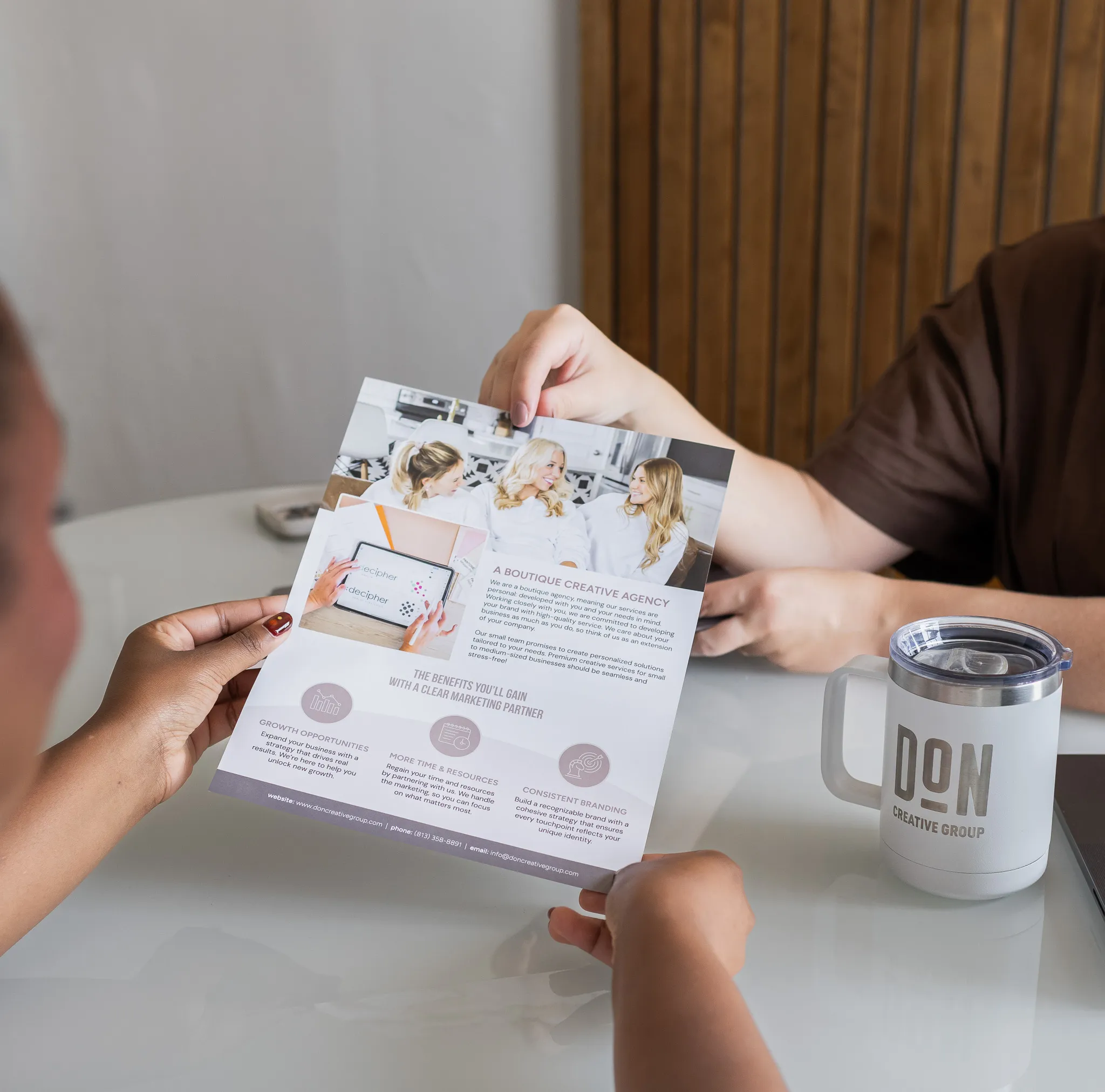 Two people reviewing a creative agency brochure during an in-person brand consultation