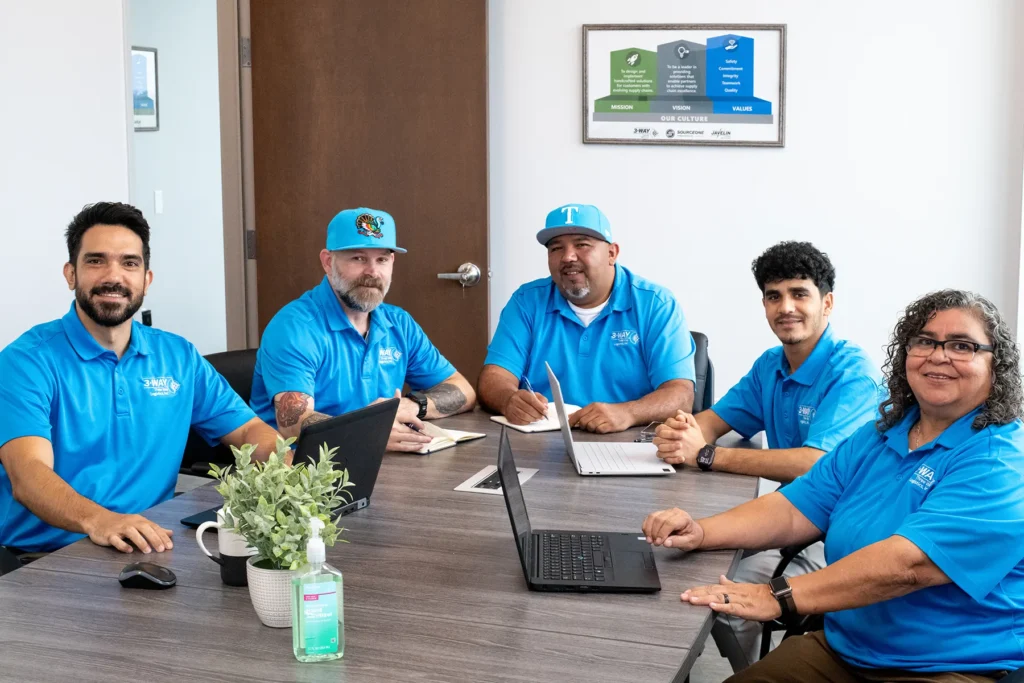 Three Way Logistics leadership team meeting in office Three Way Logistics team members seated at a conference table during an office meeting