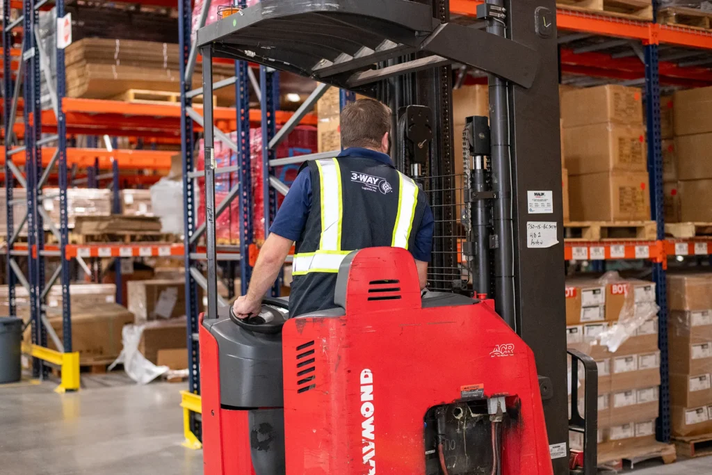 Forklift Operations Inside Logistics Warehouse Warehouse forklift operator moving inventory inside a logistics distribution center