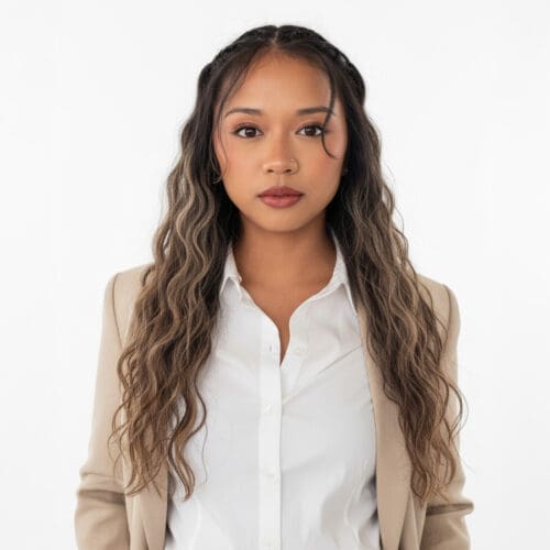 Professional woman wearing a beige blazer and white blouse against a white background